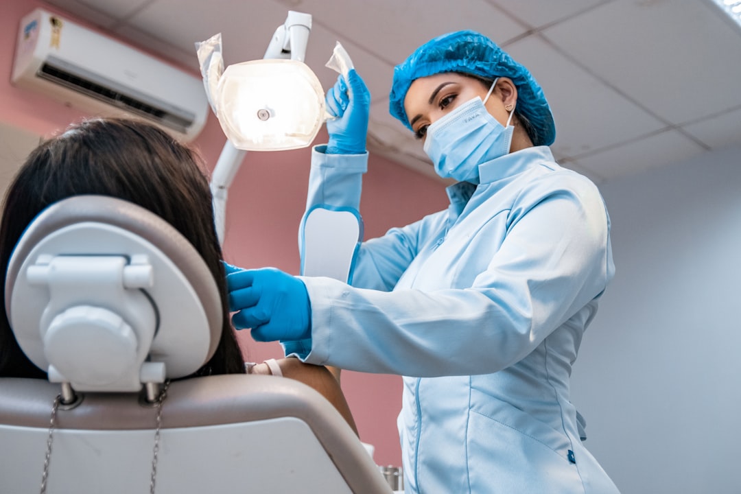 a-woman-getting-her-teeth-brushed-by-a-dentist-7n50uixcbv8